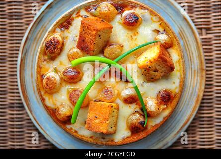 Französische Zwiebelsuppe reichen Rinderbrühe mit karamellisierten Perlzwiebeln, Schweizer Käse und Paprika Flake Croutons Stockfoto