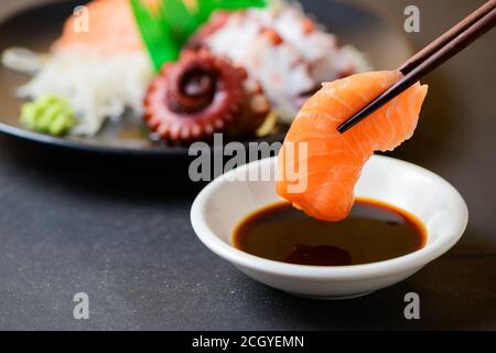 Sashimi mit frischem Lachs auf Essstäbchen, japanisches Speisekonzept Stockfoto