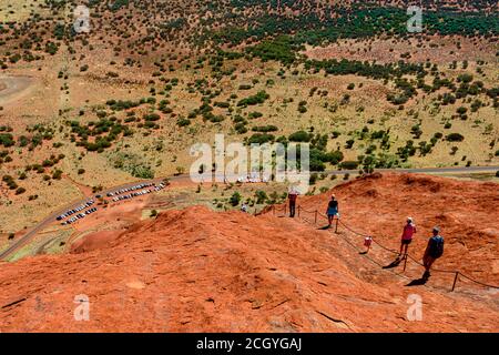 Tourist Klettern die steilen Klippen des roten Berg massiv - Uluru Rock, Ayers Rock. Australien Stockfoto