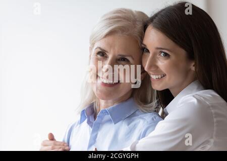 Lächelnd ältere Mutter und Erwachsene Tochter umarmt Stockfoto