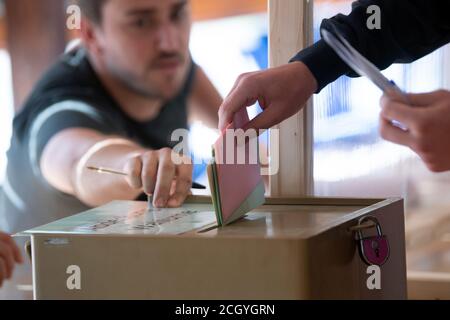 Aachen, Deutschland. September 2020. Ein Wähler reicht seine Stimme ein. In Nordrhein-Westfalen haben am Sonntag Kommunalwahlen begonnen. Rund 14 Millionen Wahlberechtigte sind aufgerufen, für Bürgermeister und oberbürgermeister, Kreisräte und die Räte der lokalen Parlamente zu stimmen. Quelle: Federico Gambarini/dpa/Alamy Live News Stockfoto