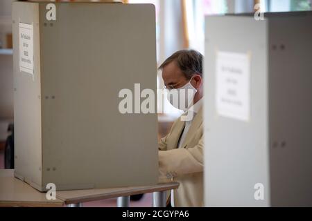 Aachen, Deutschland. September 2020. Der Ministerpräsident von Nordrhein-Westfalen, Armin Laschet (CDU), füllt seine Stimmzettel in der Wahlkabine mit einem Mundschutz aus. Am Sonntag begannen die Kommunalwahlen in Nordrhein-Westfalen. Rund 14 Millionen Wahlberechtigte sind aufgerufen, für Bürgermeister, oberbürgermeister, Kreisräte und die Räte der lokalen Parlamente zu stimmen. Quelle: Federico Gambarini/dpa/Alamy Live News Stockfoto