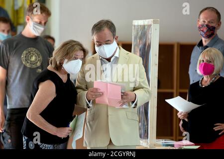 Aachen, Deutschland. September 2020. Der Ministerpräsident von Nordrhein-Westfalen, Armin Laschet (CDU, M), und seine Frau Susanne (l.) warten im Wahllokal auf die Abstimmung. Am Sonntag begannen die Kommunalwahlen in Nordrhein-Westfalen. Rund 14 Millionen Wahlberechtigte sind aufgerufen, über Bürgermeister und oberbürgermeister, Kreisräte und die Räte der lokalen Parlamente abzustimmen. Quelle: Federico Gambarini/dpa/Alamy Live News Stockfoto