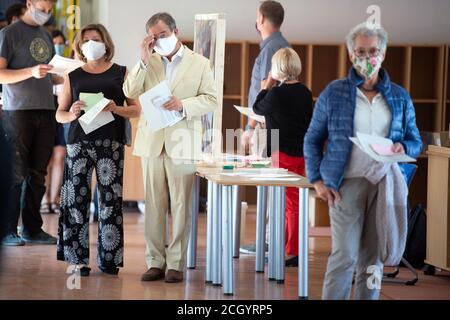 Aachen, Deutschland. September 2020. Der Ministerpräsident von Nordrhein-Westfalen, Armin Laschet (CDU, M), und seine Frau Susanne (l.) warten im Wahllokal auf die Abstimmung. Am Sonntag begannen die Kommunalwahlen in Nordrhein-Westfalen. Rund 14 Millionen Wahlberechtigte sind aufgerufen, über Bürgermeister und oberbürgermeister, Kreisräte und die Räte der lokalen Parlamente abzustimmen. Quelle: Federico Gambarini/dpa/Alamy Live News Stockfoto