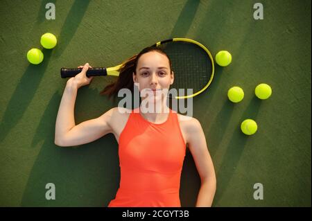 Müde weibliche Tennisspielerin liegt auf dem Platz Stockfoto