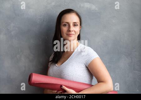 Fitness Frau bereit für das Training stehend hält Yoga-Matte. Stockfoto