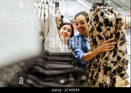 Zwei Mädchen Wahl Kleider im Bekleidungsgeschäft Stockfoto