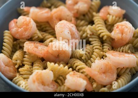 Fusilli mit Garnelen und Pesto in einer blauen Schale, flacher Fokus Stockfoto