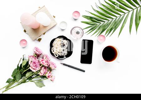 Schreibtisch mit Schreibtisch. Arbeitsplatz mit Pinsel, Laptop, rosa Blumen, Telefon auf weißem Hintergrund. Flache Komposition. Draufsicht, Home Office-Arbeitsbereich Stockfoto