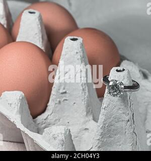 Verlobungsring. Isoliert. Weißer Platin-Diamant in der Mitte und Eier im Hintergrund.Stockbild Stockfoto