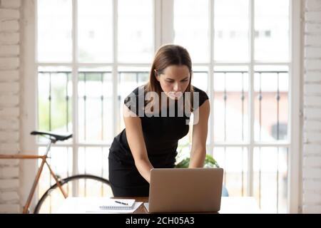 Fokussierte kaukasische Mitarbeiterin arbeitet im Büro am Laptop Stockfoto