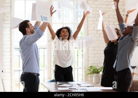 Überglücklich multiethnische Kollegen tanzen feiern Erfolg im Büro Stockfoto
