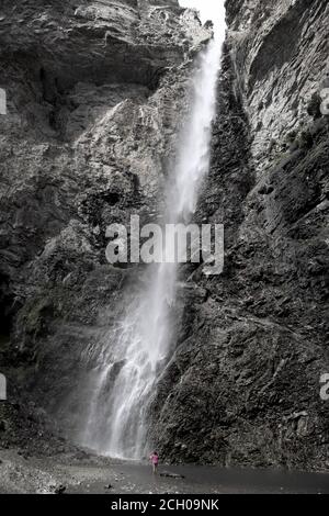 Eine Person im Saint Benoit Wasserfall Avrieux Maurienne Valley Savoie France. 80 m hoch. Der Saint-Benoit Bach entspringt am Fond d'Aussois. Stockfoto