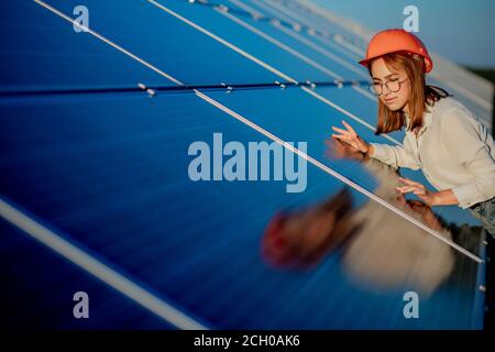 Schöne junge Ingenieur in der Nähe von Sonnenkollektoren im Freien, Green Energy Konzept Stockfoto