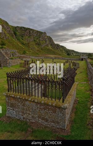Ecclesgreig Begräbnisplatz am Fuße der dramatischen Klippen im St. Cyrus National Nature Reserve, mit seinen alten Grabsteinen, ruinierte Kirche und watc Stockfoto