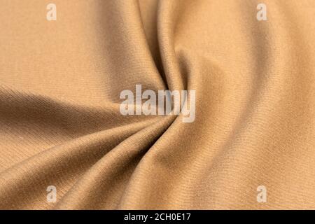 Teurer Velours-beige-Stoff, Kaschmir-Textil, Veloursleder- und Gämseneffekt, Baumwollpolster, synthetische Materialien, Polyesterfaser. Stockfoto