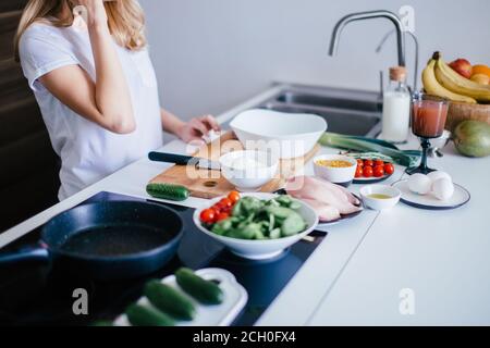 Gesunde Ernährung Zutaten stehen in der Reihe. Bio-Lebensmittel Zutaten, Superfoods: Hühnerfilet, Mais, Milch, Eier, Obst, Gemüse. White Table Copy Stockfoto