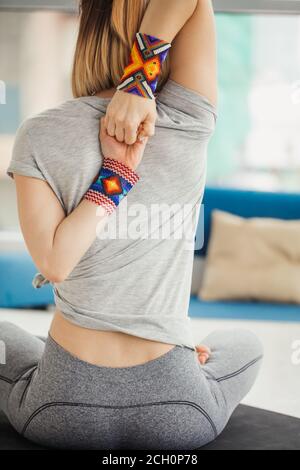 In der Nähe der weiblichen Händen hinter dem Rücken, Frau Üben Yoga, sitzen in Kuh Gesicht übung, Gomukasana darstellen, arbeiten, tragen weiße Sportswear, Stockfoto