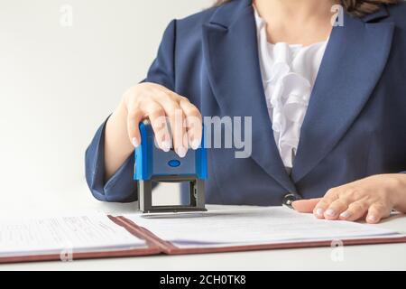 Offizieller Notar, Büroangestellter, der Stempel auf Dokumente legt Stockfoto