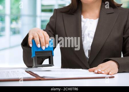 Geschäftsfrau Schreiber Putting Stamp auf Dokumente im Büro, Office-Konzept Stockfoto