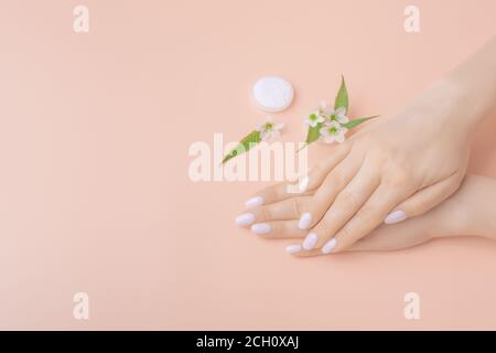 Hände einer Frau mittleren Alters mit den Handflächen nach unten. Modell auf dem Schreibtisch. Nahaufnahme der Vorlage mit Kopierbereich. Draufsicht. Handpflegekonzept Stockfoto