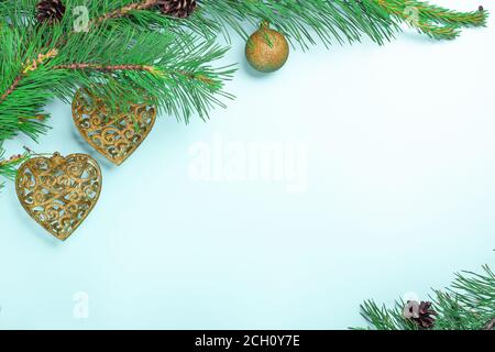 Tannenzweige und Weihnachtsspielzeug. Weihnachts- oder Neujahr-Karte auf hellblauem Hintergrund Stockfoto