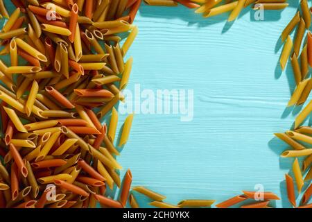 Ungekochte getrocknete Pasta auf Holzhintergrund. Leerzeichen für Text. Draufsicht. Stockfoto