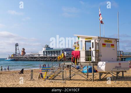 Bournemouth, Dorset, Großbritannien. September 2020. Such- und Rettungscoastguards gesehen Suche am Bournemouth Strand mit Hubschrauber fliegen über. RNLI-Rettungsschwimmer ist nicht in der Rettungsschwimmer-Kiosk-Hütte und schaut durch ein Fernglas hinaus. Quelle: Carolyn Jenkins/Alamy Live News Stockfoto