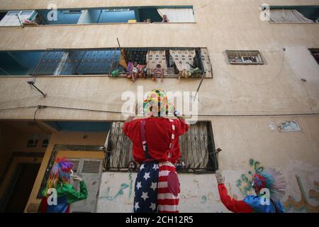 Khan Yunis, Palästina. September 2020. Ein palästinensischer Jugendlicher, der als Clowns gekleidet war, inszenierte eine Straßenvorstellung, um die Kinder zu Hause zu unterhalten, wegen des Coronavirus COVID19 Ausbruchs in Khan Yunis im südlichen Gazastreifen. (Foto von Yousef Masoud/INA Photo Agency) Quelle: SIPA USA/Alamy Live News Stockfoto