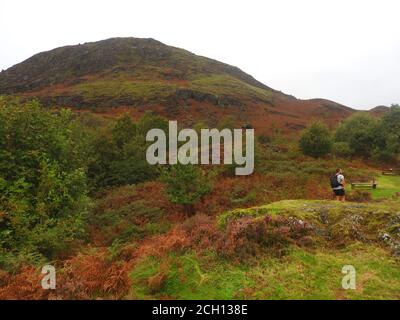 Ein Wanderer umgeht den Fuß des Falles von Esoncan, Glen Trool, Dumfries und Galloway (DG8 6TA) im September 2020 in der Nähe des Robert the Bruce (Earl of Carrick) Memorial, in der Nähe von Loch Troon, Galloway (2020 Foto). - die Schlacht von Glen Trool fand im ersten Krieg der schottischen Unabhängigkeit statt, im April 1307. Glen Trool ist ein schmaler glen im südlichen Hochland von Galloway, Schottland, in dem sich Loch Trool (hinter dem Denkmal) befindet. Als sich die englischen Soldaten in einer einzigen Datei dem schmalen glen näherten, schleuderten Bruce's Männer Felsbrocken und Pfeile nach unten auf sie und sicherten sich einen Sieg Stockfoto