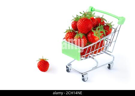 Frische reife Erdbeeren in einem Mini-Einkaufswagen isoliert auf weißem Hintergrund. Konzept eines Supermarkts, Marktes oder Lebensmittelladens. Platz kopieren. Stockfoto