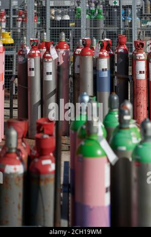 Gasflaschen im Lagerplatz Verschiedene gasförmige Chemikalien, die in Stahlflaschen gelagert werden. Stockfoto