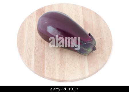 Aubergine auf Holzschneidebrett. Eine frische Aubergine auf weißem Hintergrund. Einzelne reife Aubergine isoliert auf weißem Hintergrund Stockfoto