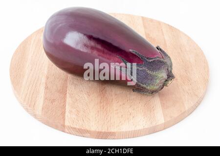 Frische gesunde Auberginen auf Holzhintergrund. Frische Aubergine liegt auf einem hölzernen Schneidebrett. Sommer Auberginen Ernte bereit zum Kochen auf einer Holzboa Stockfoto