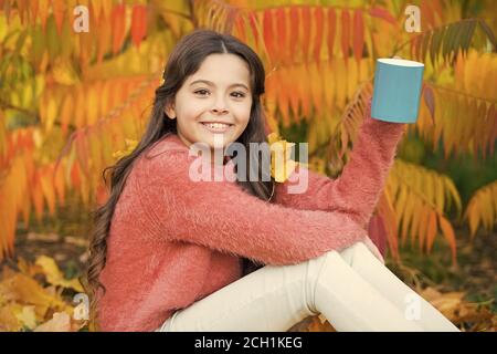 Jeden Morgen beginnt mit Kaffee. Glückliches Kind halten Tasse mit heißem Getränk auf Herbstmorgen. Kleines Mädchen trinken Kaffee oder Tee. Frühstück wakeup. Stockfoto