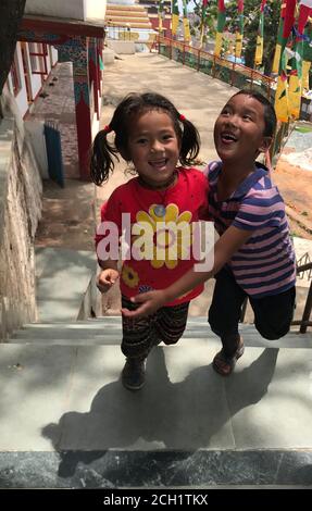 Fröhliche lächelnde Kinder laufen die Straße hinunter in Kathmandu, Nepal. Nepalesische Kinder. Baby glücklich Lächeln. Stockfoto