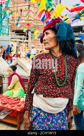 Nepalesische ältere Frau mit Nasenring in traditioneller Kleidung. Buddhistisches Fest in Kathmandu, Nepal. Hochformat in Halbbild. Attraktive asiatische Erscheinung. Stockfoto