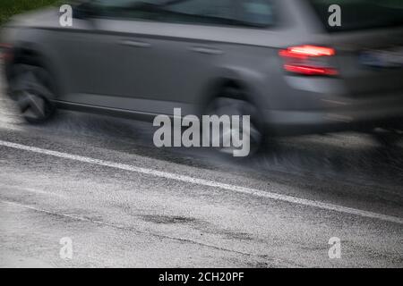 Silver Auto fahren auf einer nassen Straße im Regen Stockfoto