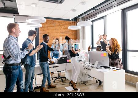 Geschäftsleute verschiedener Nationalitäten sind Triumph über eine besiegte Unternehmen Stockfoto