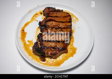 Ein perfekt gegartes Steak mit Grilllinien, die auf einem Reiner Weißer Hintergrund Stockfoto