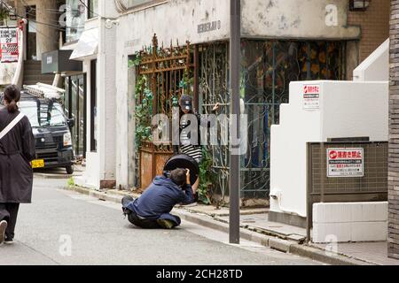 Harajuku, Tokio/Japan - Juni 2018: Ein Model posiert für einen Fotografen am frühen Morgen auf einer leeren Takeshita-Straße vor den Einkaufsmassen. Stockfoto