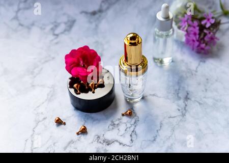 Glasflasche mit Tropf, feuchtigkeitsspendende und heilende Haut Serum mit Vitamin C auf Marmor Hintergrund. Vitaminkapseln als Ergänzung zu einer Creme oder Stockfoto