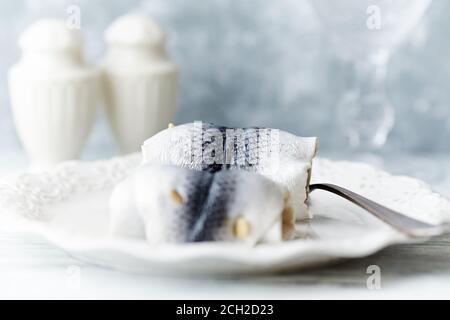 Traditionelle Rollmops, eingelegter Hering auf hellem Holzhintergrund. Selektiver Fokus. Stockfoto