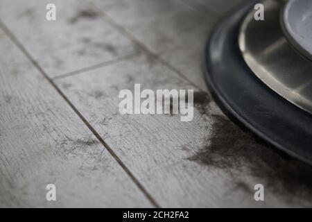 Kurze schwarze männliche Haare liegen nach einem Haarschnitt auf dem Boden in der Nähe des Barbershop-Sessels des Friseursalons. Hygiene Saloon muss gereinigt werden Stockfoto