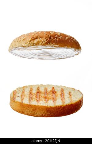 Zwei Stücke von einem Brötchen mit Sesam für Burger Stockfoto