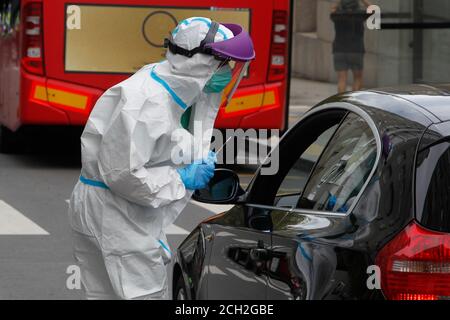 A Coruna-Spain -August 18, 2020: Ein Mitarbeiter im Gesundheitswesen verwendet einen PCR-Test (Mund- und Nasenabstrich) auf eine Person in einem Auto, um die Anwesenheit oder Abwesenheit zu bestimmen Stockfoto