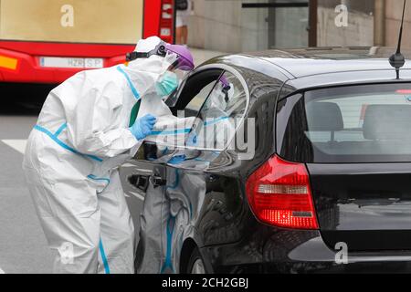A Coruna-Spain -August 18, 2020: Ein Mitarbeiter im Gesundheitswesen verwendet einen PCR-Test (Mund- und Nasenabstrich) auf eine Person in einem Auto, um die Anwesenheit oder Abwesenheit zu bestimmen Stockfoto
