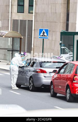 A Coruna-Spain -August 18, 2020: Ein Mitarbeiter im Gesundheitswesen verwendet einen PCR-Test (Mund- und Nasenabstrich) auf eine Person in einem Auto, um die Anwesenheit oder Abwesenheit zu bestimmen Stockfoto