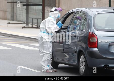 A Coruna-Spain -August 18, 2020: Ein Mitarbeiter im Gesundheitswesen verwendet einen PCR-Test (Mund- und Nasenabstrich) auf eine Person in einem Auto, um die Anwesenheit oder Abwesenheit zu bestimmen Stockfoto