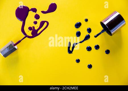 Spritzer von lila Nagellack gefroren in Bewegung auf gelbem Hintergrund.Blau und lila Farbe Splash.Beautiful Nagellack Muster.Nagellack Tropfen. Stockfoto